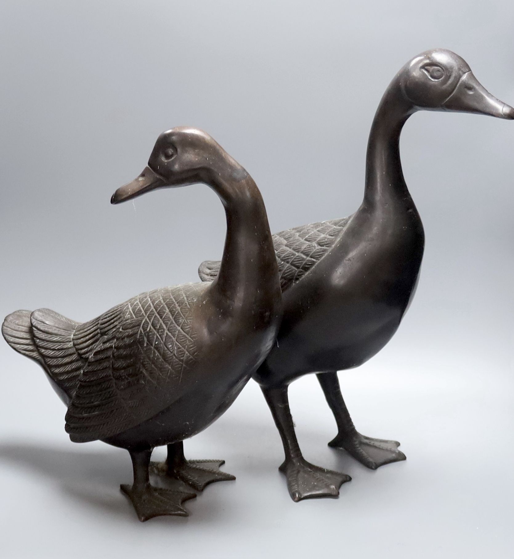 A pair of modern Chinese bronze models of geese, largest 48cm